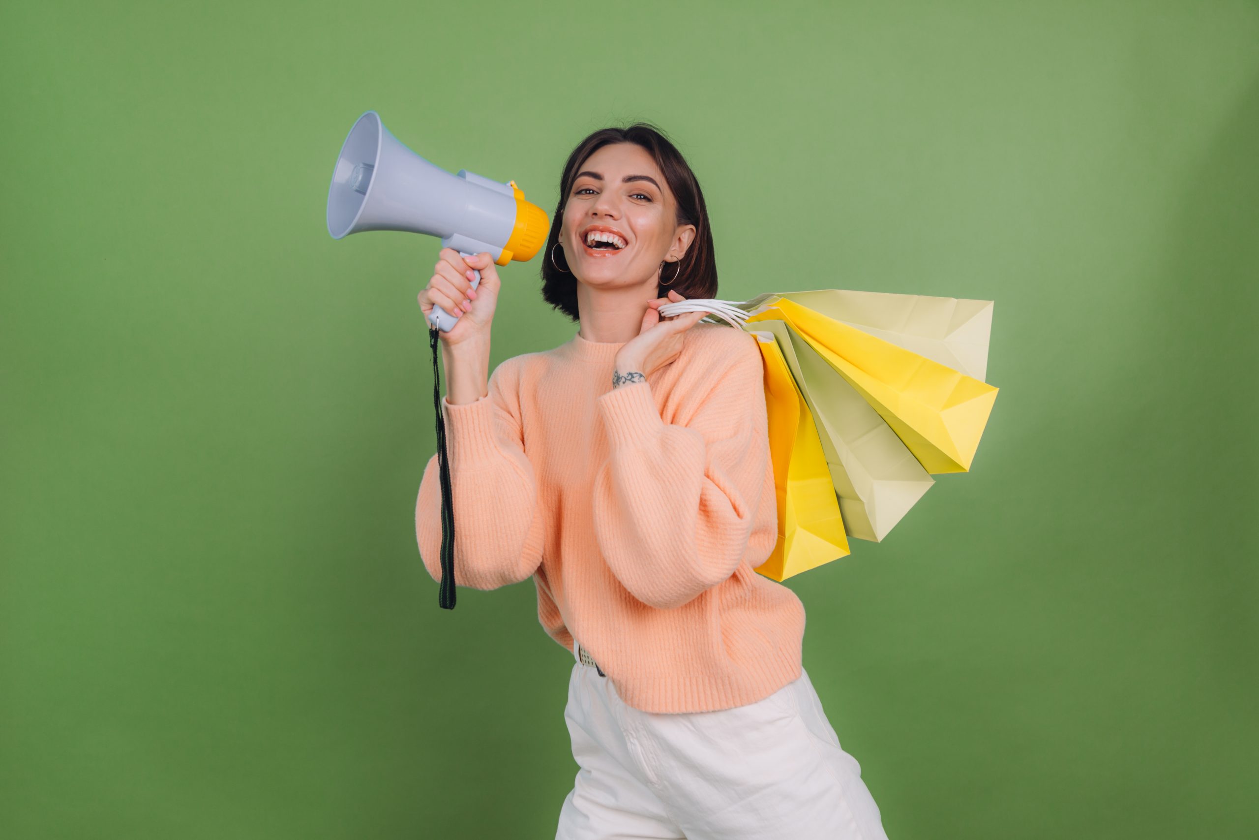 mulher com megafone e sacolas de compra